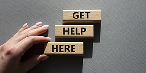 person holding wooden blocks that say Get Help Here